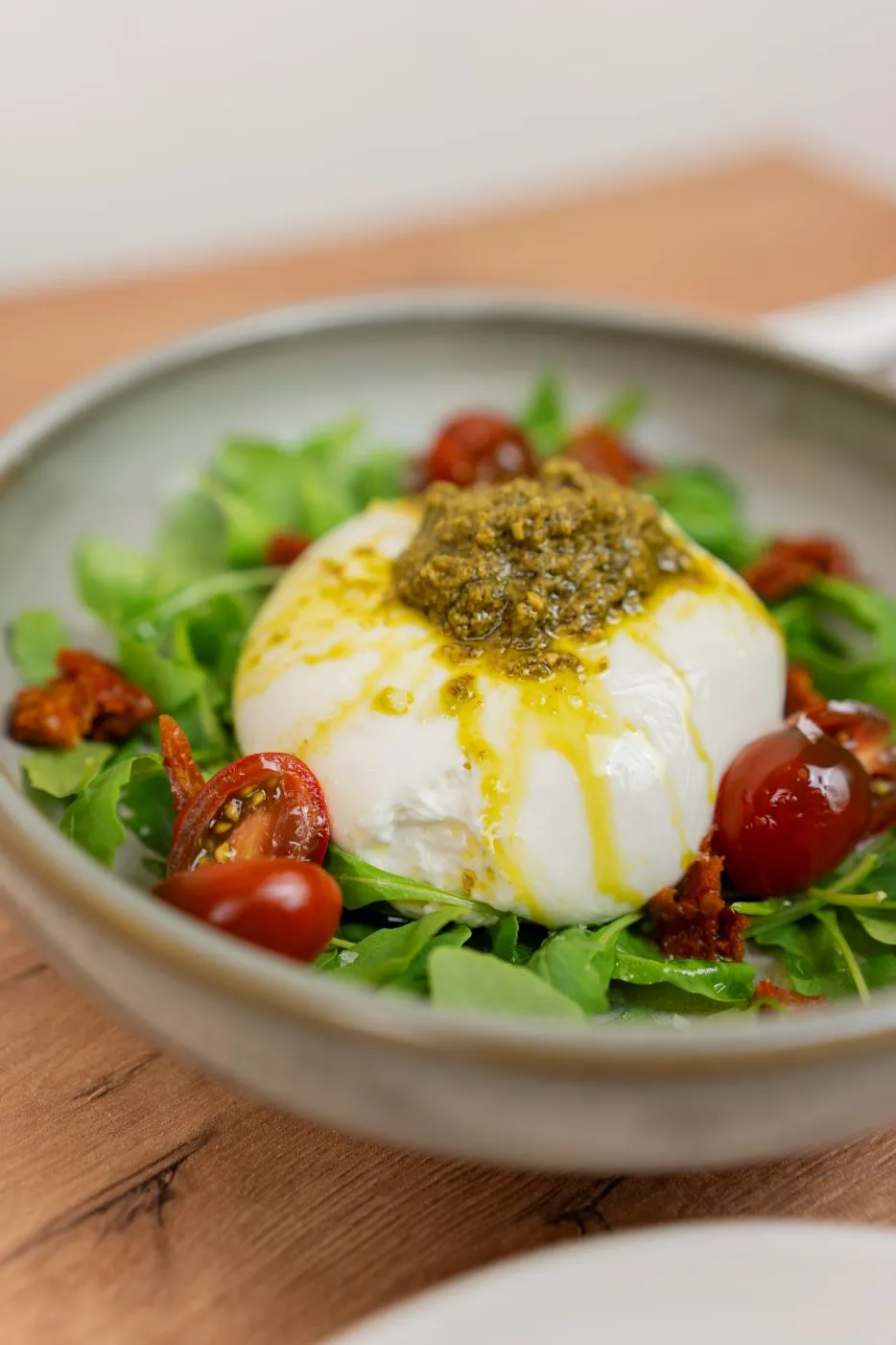 Burrata sobre rúcula, emulsión de trufa blanca y pesto verde